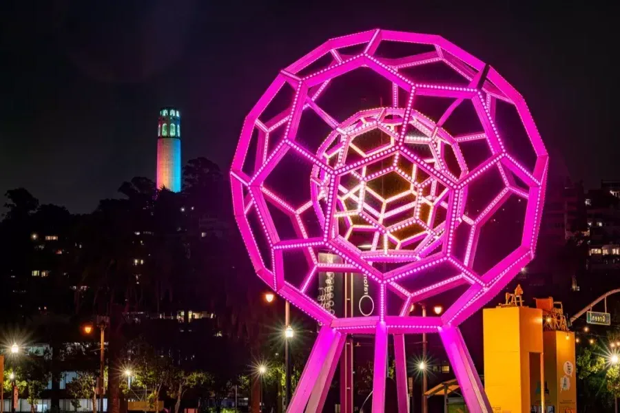 Buckyball brille au premier plan tandis que la Coit Tower brille au loin.